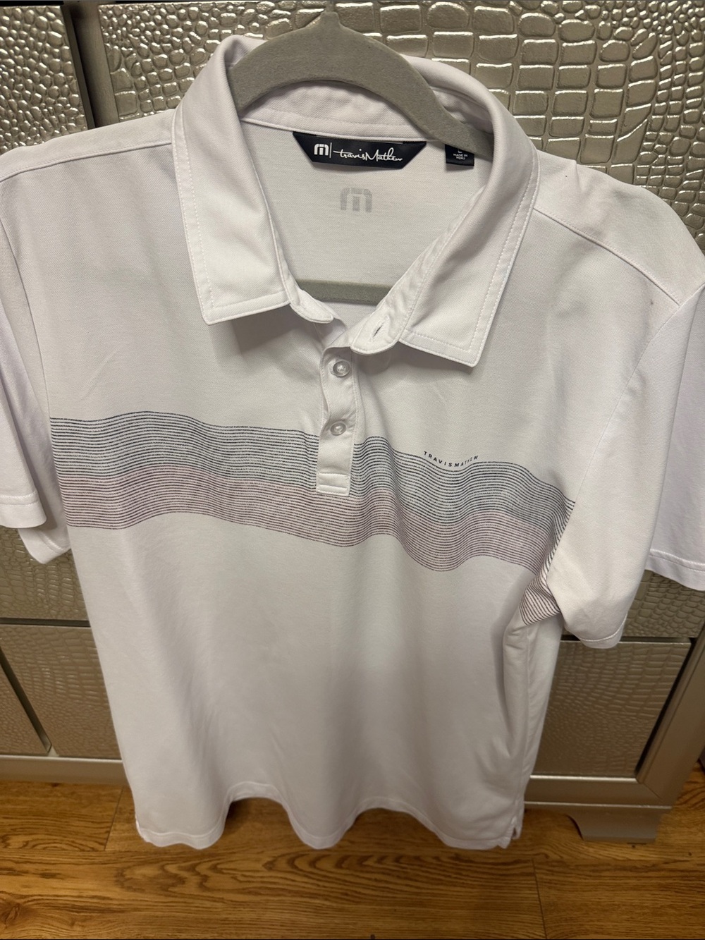 Travis Mathew White Polo with Subtle Blue and Pink Chest Stripe
